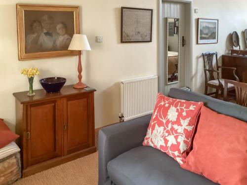 a living room with a couch and a lamp at Stepping Gate Cottage in Scalby