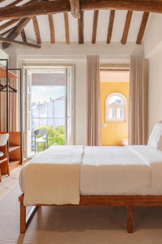 a bedroom with a large bed and a large window at Rosário Suites Townhouse in Porto