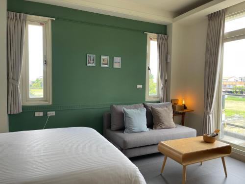 a bedroom with a bed and a couch and windows at 小k咖啡B&B 寵物友善 咖啡廳民宿 in Sanxing