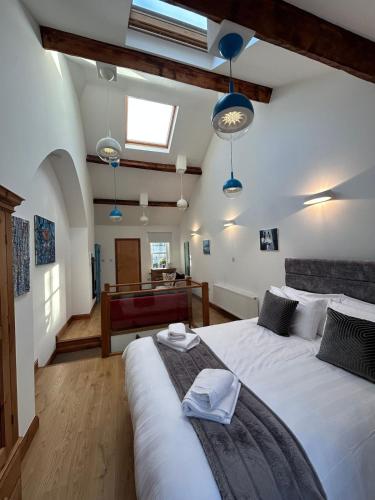 a bedroom with a large white bed with blue lights at Orebank Cottage in Millom