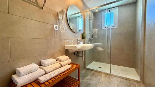 a bathroom with a sink and a shower and towels at Hotel Celymar in Benidorm