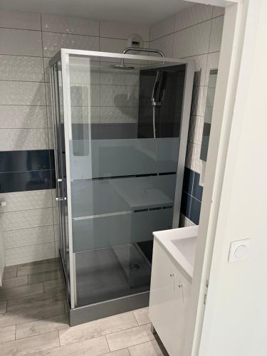 a glass shower in a bathroom with a sink at La Berge in La Flocellière