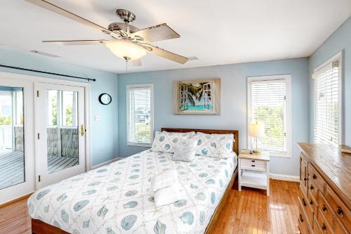 ein Schlafzimmer mit Bett und Deckenventilator in der Unterkunft Palms Delight in Kitty Hawk