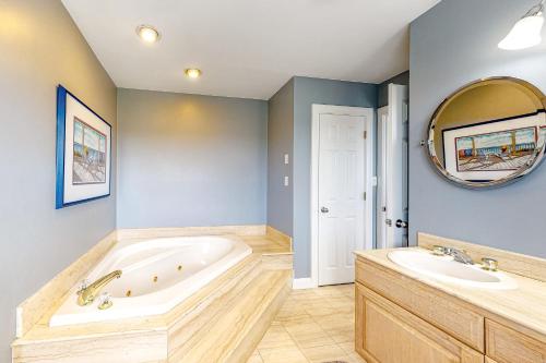 ein Badezimmer mit Badewanne, zwei Waschbecken und einem Spiegel in der Unterkunft Palms Delight in Kitty Hawk