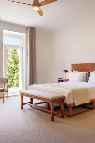 a bedroom with a large bed and a bench at Rosário Suites Townhouse in Porto