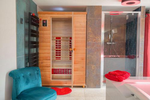 a bathroom with a blue chair next to a shower at Expérience des sens in Grézieu-la-Varenne