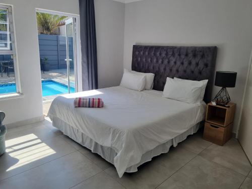 a bedroom with a large bed with a large window at Frankie's Nest in Cape Town