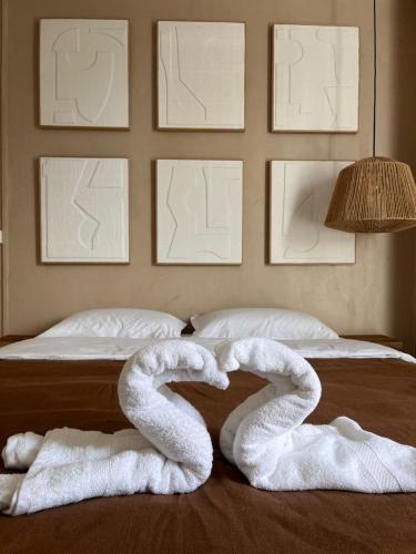 a bed with two swan towels laying on it at Studio Tulum - jacuzzi privé - face à la mer in Tartane