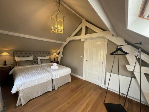 a bedroom with a bed and a chandelier at Residentie Eys Anno 1929 in Eys