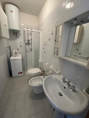 a white bathroom with a sink and a toilet at Residence The Yellow Fish with Pool in Manerba del Garda