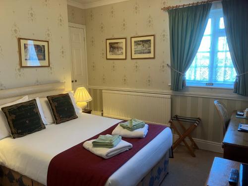 a bedroom with a bed with towels on it at Chapel House in Atherstone