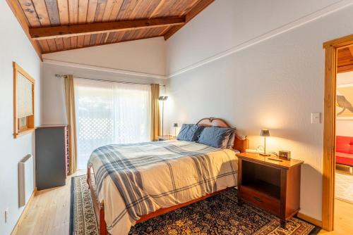a bedroom with a bed and a window at Green Tree Cottage in Mendocino