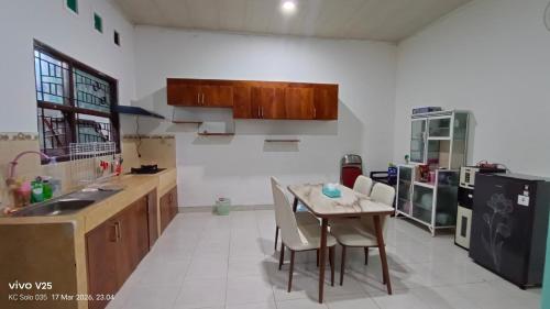 a kitchen with a table and chairs in it at Homestay Karimun in Grogol