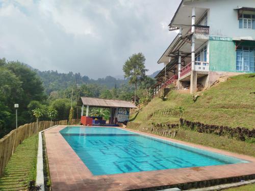 a swimming pool in front of a house at Villa Mega molek in Pondok Cipaseban