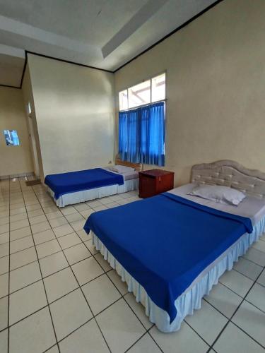 a bedroom with two beds and a window at Villa Mega molek in Pondok Cipaseban