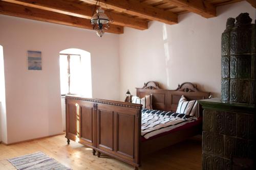 een slaapkamer met een houten bed en een raam bij Grand Balaton House in Kővágóörs