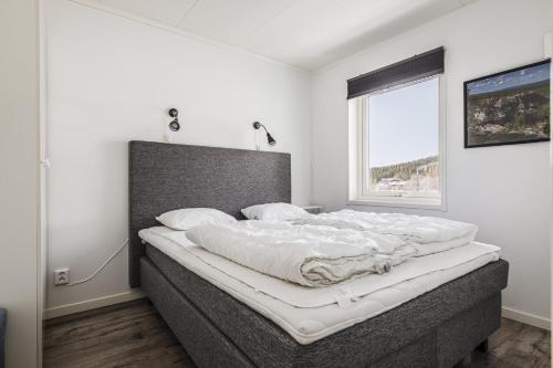 ein großes Bett in einem Zimmer mit Fenster in der Unterkunft Parkstigens Lägenheter in Funäsdalen