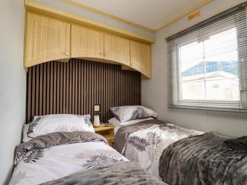 a bedroom with two beds and a window at The Granada at Argraig in Holyhead