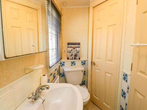 a bathroom with a white toilet and a sink at The Granada at Argraig in Holyhead