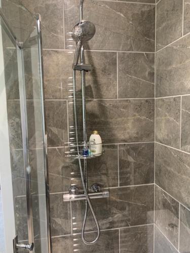 a shower with a shower head in a bathroom at The Annexe in Kirkcudbright