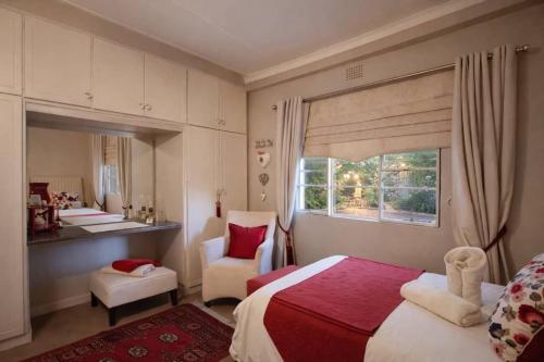 a bedroom with a bed and a chair and a mirror at Tarentaal Guest Farm Etosha National Park Namibia in Okaukuejo
