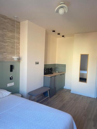 a bedroom with a bed and a table and a kitchen at Les Paquebots - Hôtel & Restaurant in Port-Vendres