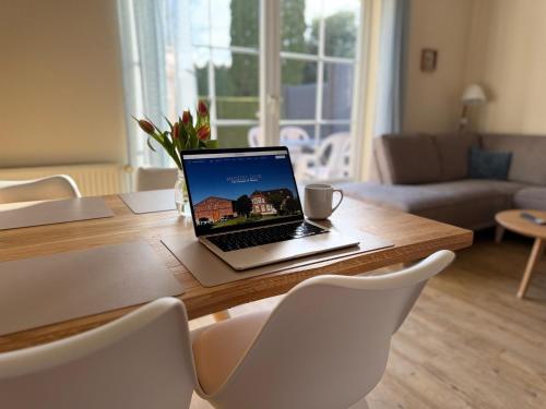 a laptop computer sitting on top of a wooden table at Backhuus 3 in Fehmarn