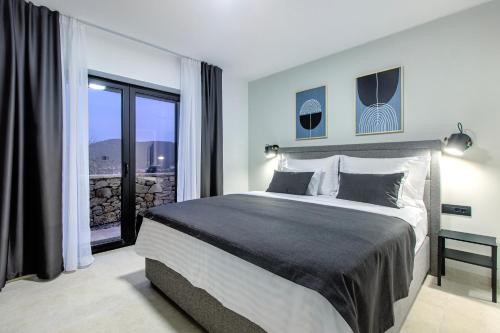 a bedroom with a large bed and a large window at Villa Mare Private Stone Villa with Heated Pool and Garden in Vinišće