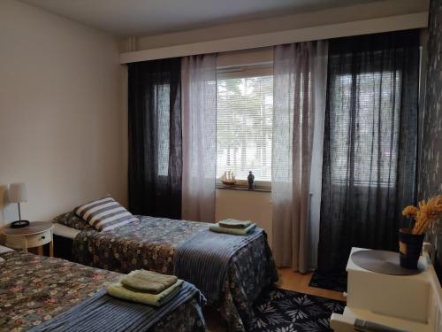 a bedroom with two beds and a window at Yyterin portti in Pori