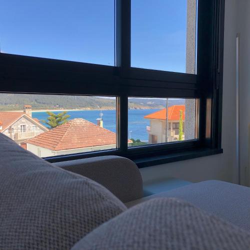 a room with a window with a view of the ocean at Refugio climático en Finisterre frente a la playa con vistas al mar!! in Fisterra