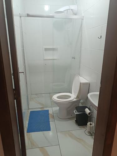 a white bathroom with a toilet and a sink at Relaxe à Beira-Mar com pé na areia! in Tramandaí