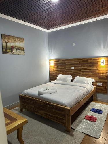 a bedroom with a large bed with a wooden headboard at Posh lounge gardens in Gatimu