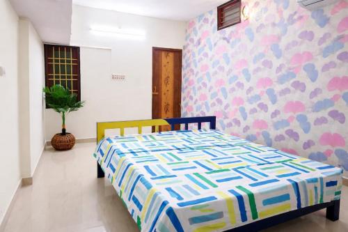 a bedroom with a bed with a colorful patterned wall at Vasan villa 2BHK in Pondicherry