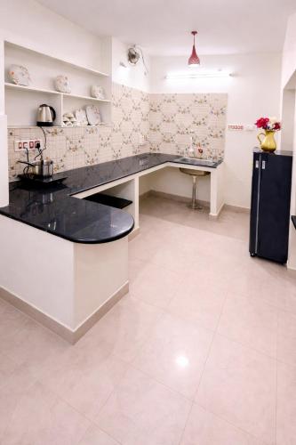 a kitchen with a black counter and a refrigerator at Vasan villa 2BHK in Pondicherry