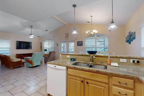 a kitchen with a sink and a living room at Take Me To The Beach in Rockport