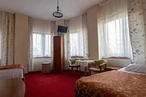 a hotel room with a bed and a table and chairs at Hotel Anka in Słubice