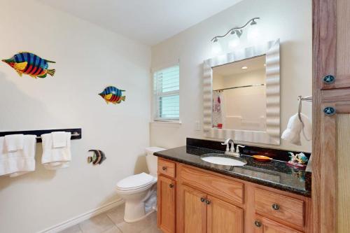 a bathroom with a sink and a toilet and a mirror at South Pearl Sailfish in Rockport