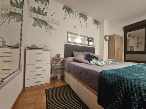 ein Schlafzimmer mit einem Bett, einer Kommode und einem Spiegel in der Unterkunft Miño Beach in Miño