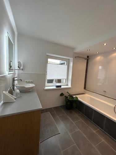 a bathroom with a tub and a sink and a bath tub at MühlengasseONE in Lenzing