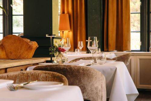 a dining room with tables and chairs with wine glasses at Restaurant & Hotel Hoog Holten in Holten