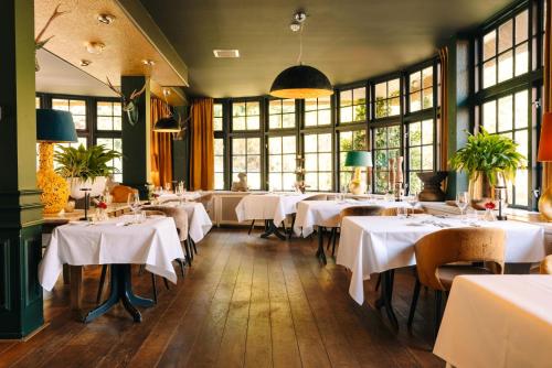 a restaurant with tables with white tablecloths at Restaurant & Hotel Hoog Holten in Holten