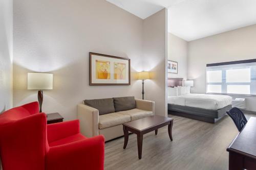 a hotel room with a couch and a bed at Country Inn & Suites by Radisson, Jacksonville West, FL in Jacksonville