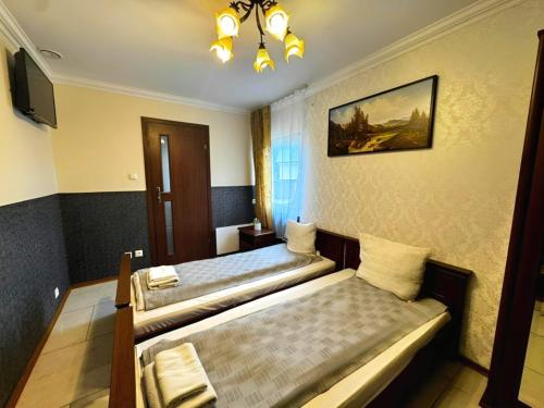 a hotel room with two beds and a tv at Zajazd Rest in Przemyśl