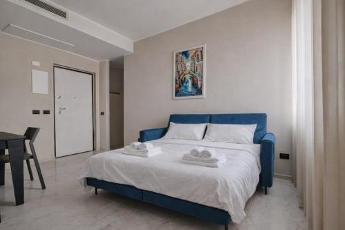 a bedroom with a blue bed with towels on it at Luxury Design Apartment-2 Steps from Duomo in Milan
