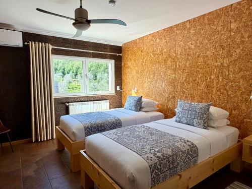 a bedroom with two beds and a window at Casa Carvalhal - Adults Only in Góis