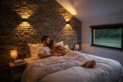 a man and a woman laying in bed with a baby at Le Domaine de Bra in Bra