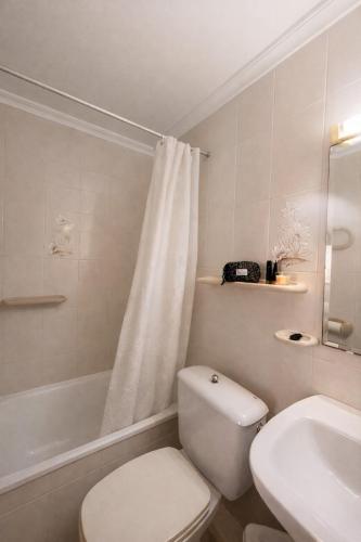 a white bathroom with a toilet and a sink at Apartamento en Xeraco in Xeraco