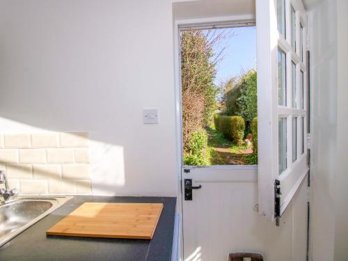 a kitchen with an open door with a window at Cheshire Views in Malpas