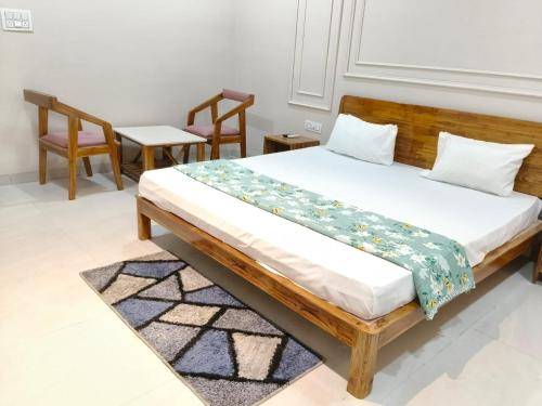 a bedroom with a wooden bed with two chairs at IR Resorts Mahasamund in Mahāsamund