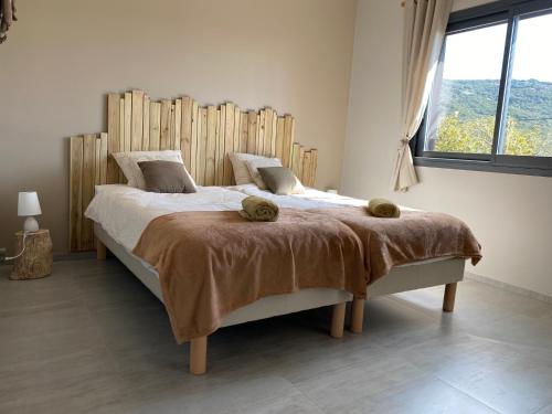 a bedroom with a large bed with a wooden headboard at Résidence Petru-Maria in Propriano